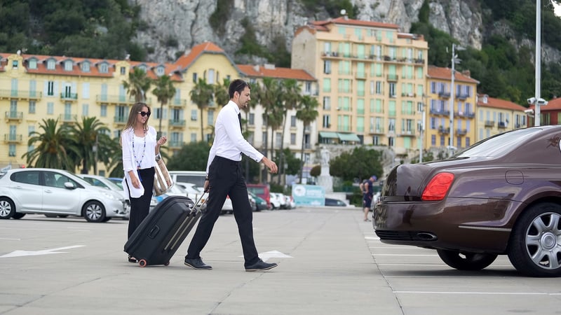 Beautiful businesswoman walking to taxi with chauffer, luxury car services
