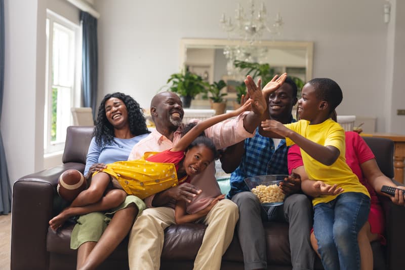 A multi-generational family sitting on a couch, a common blue zones theme