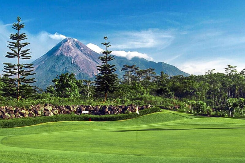 Merapi Golf Course with green surrounded by tropical forest and Merapi Volcano in the background Indonesia