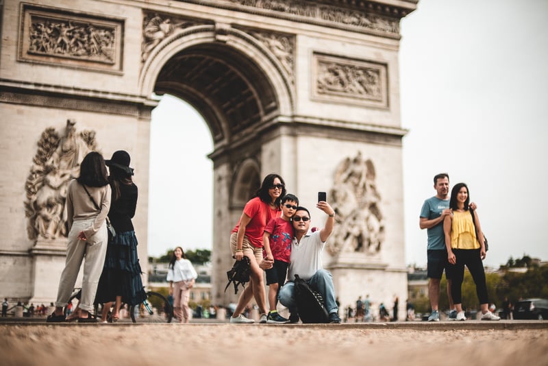 Worldschooling A young family posing for a photo in Paris, while learning around the world