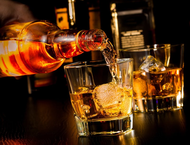 Benromach Whiskey being poured into a glass with ice 