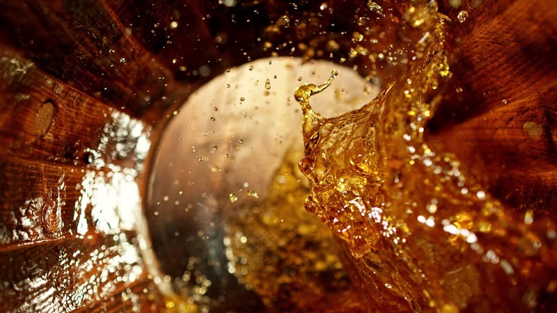 Whisky pouring into an oak barrel for aging process at Speyside Cooperage whisky distillery