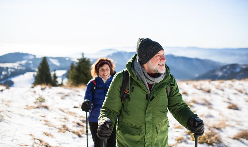 Adventure sports include man and woman snowshoeing in the mountains