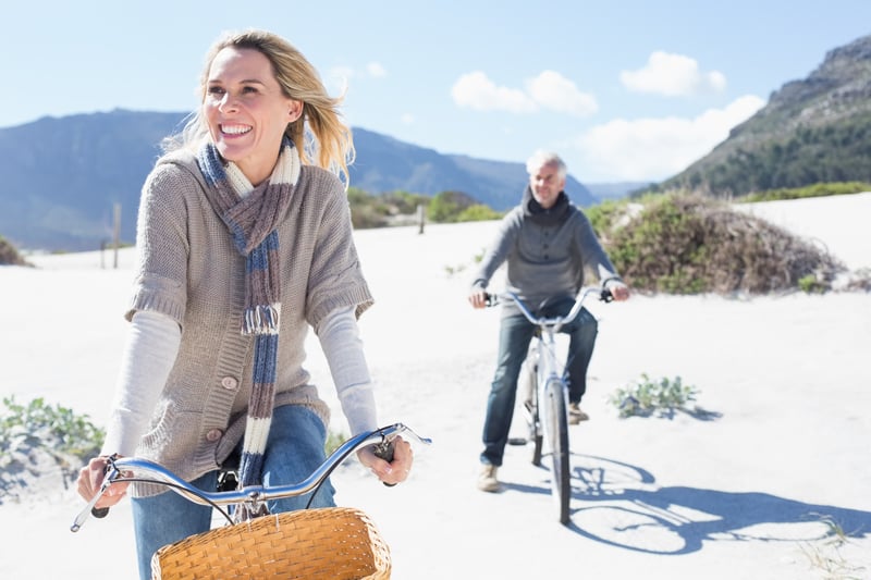 Healthy older couple on bicycles in the mountains achieving longevity