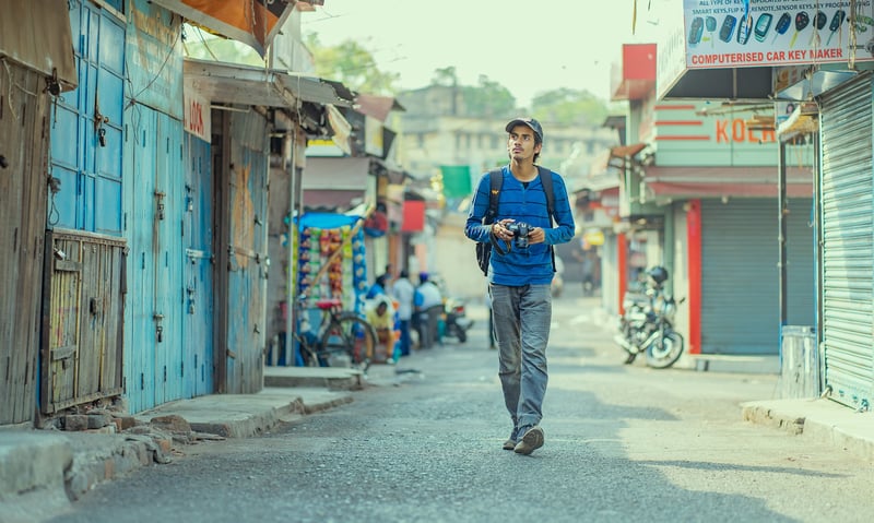 Solo traveller walking dodgy alley holding expensive camera