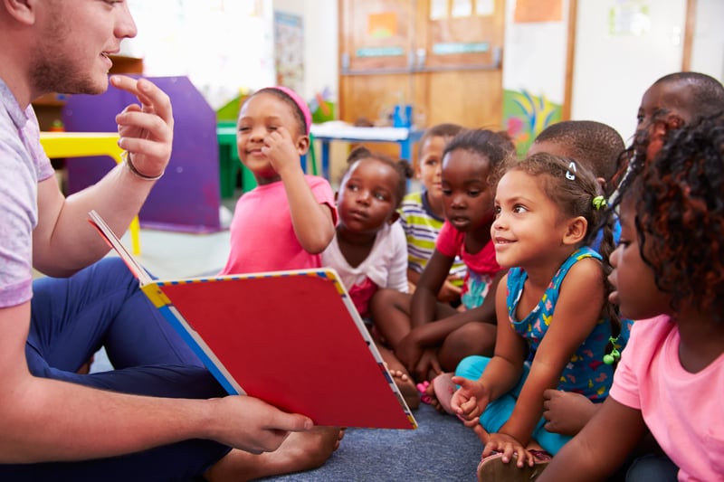 Volounteer teacher teaching a class of children the idea of being citizens of the world (1)