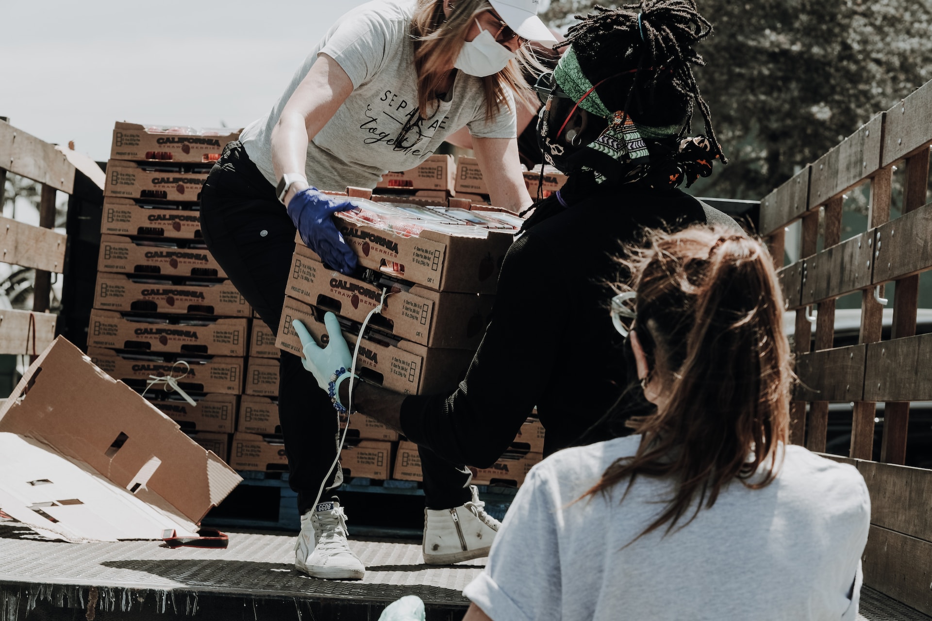 Volunteers helping unload the back of a charity truck