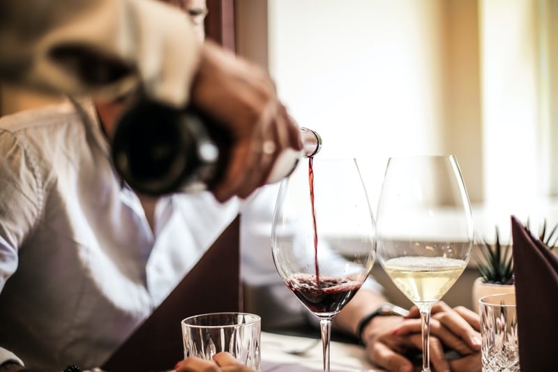 Sommelier pouring a glass of good red wine